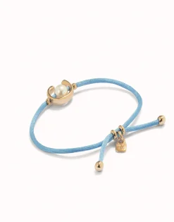 Pulsera de hilo azul con perla shell fornitura bañada en oro 18k.