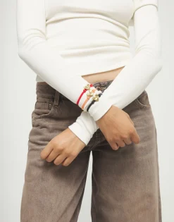 Pulsera de hilo elástico naranja con corazón bañado en oro 18k