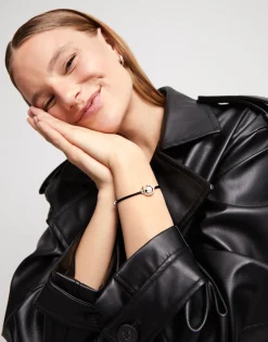 Pulsera de hilo negro con perla shell fornitura bañada en plata de ley.