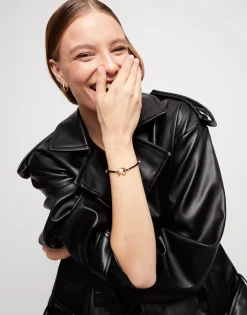 Pulsera de hilo negro con perla shell fornitura bañada en oro 18k.