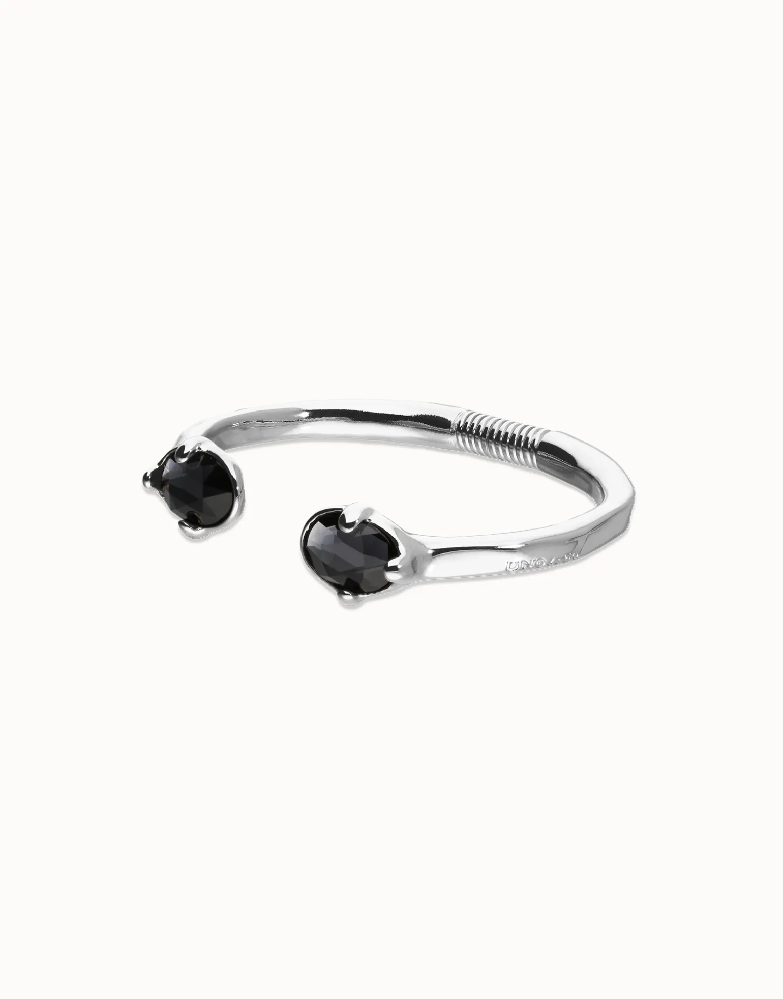 Pulsera rígida bañada en plata con dos cristales facetados ovalados negros